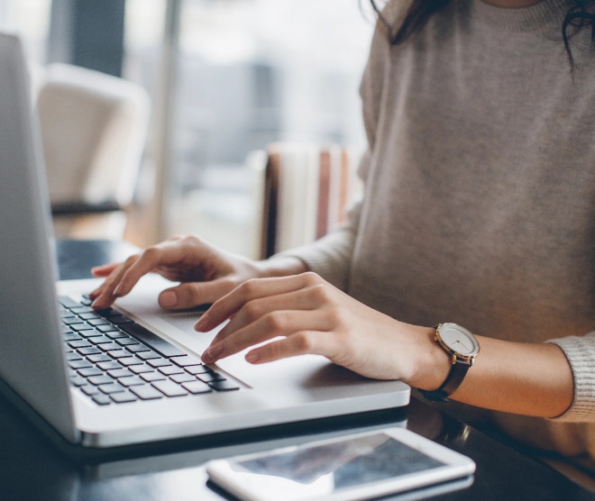 Close up image of a person typing on laptop keyboard.