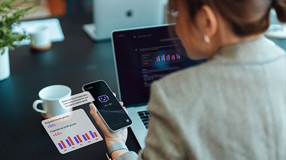 Businesswoman using AI assistant on smartphone with holographic analytics and charts, representing The AI App Store concept for integrating apps and agents into everyday workflows