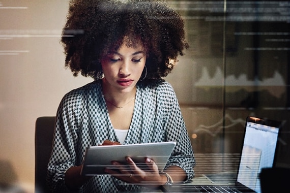image of a woman reviewing data on a tablet