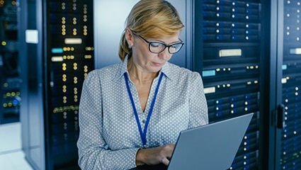 IT tech working in dark data center.
