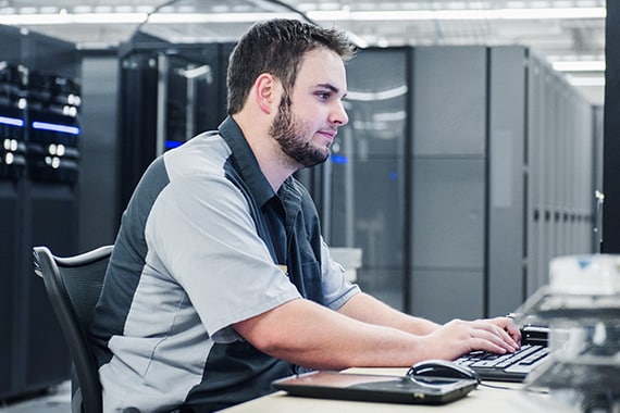 it technician in server room helping coworker on computer through chat