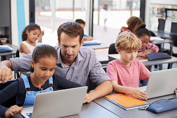 Primary students in classroom with devices