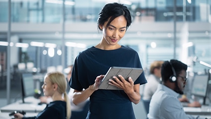 Person using tablet in bright office.