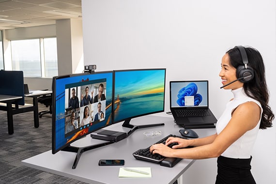 Kensington showcase image with employee working on a computer wearing a headset.