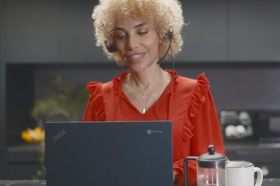 Woman with headset working on Chromebook laptop
