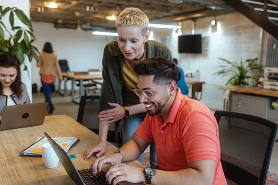 image of two employees working together on a shared laptop