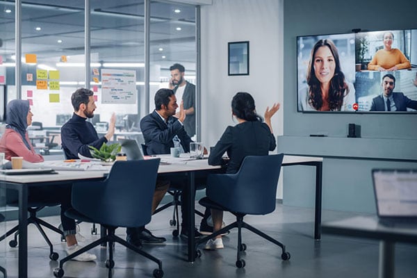 Business people do Video Conference Call with Big Wall TV in Office Meeting Room. Diverse Team of Creative Entrepreneurs at Big Table have Discussion. Specialists work in Digital e-Commerce Startup