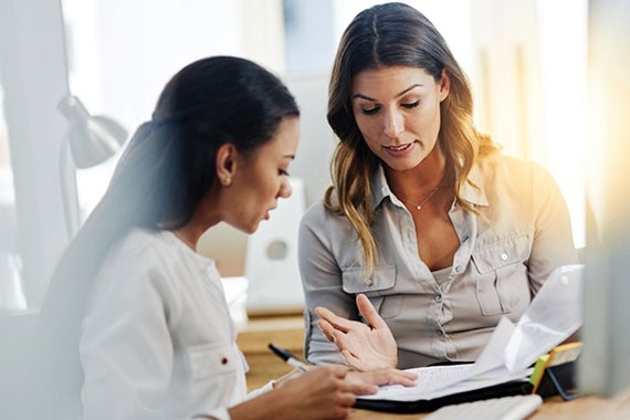 Two professionals reviewing reports to establish tagging standards and automation for transparent cloud cost management and sustainability.