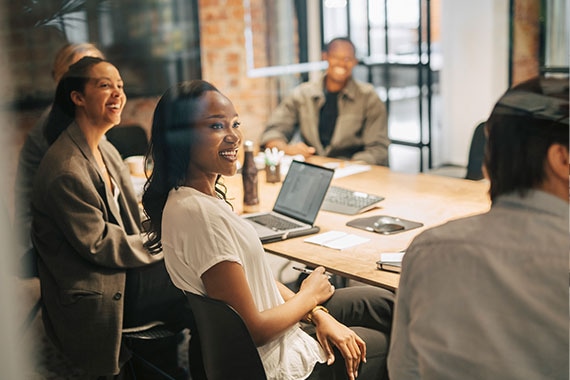 Team members collaborating around desktop computers in a shared workspace