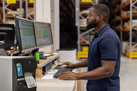 Person in warehouse using desktop computer.