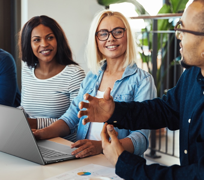 thumbnail image of a woman working on a laptop collaborating with coworkers