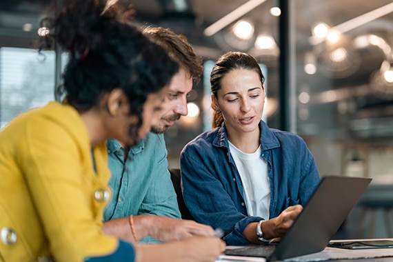 thumbnail image of a team of employees collaborating on a shared laptop computer