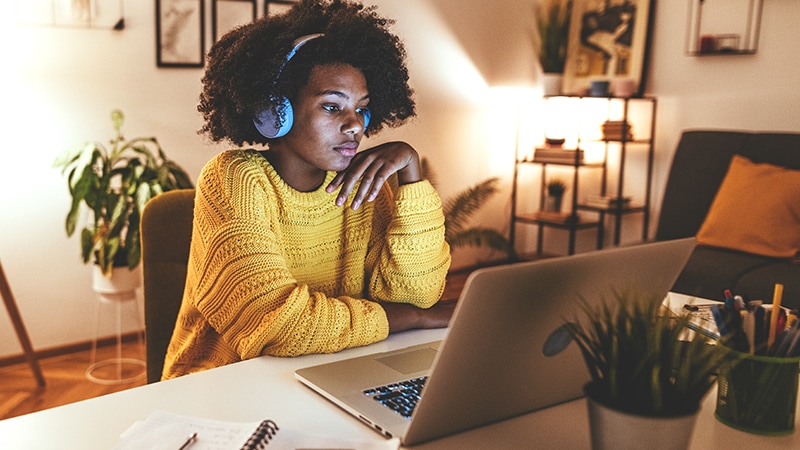 Yourng Woman Using Adobe Learn Hub on Laptop