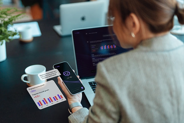Person reviewing AI assistant insights on smartphone and laptop dashboard