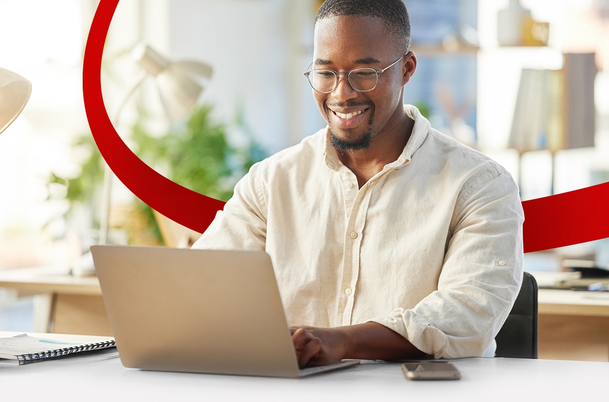 Young businessman using AI on laptop in bright room.