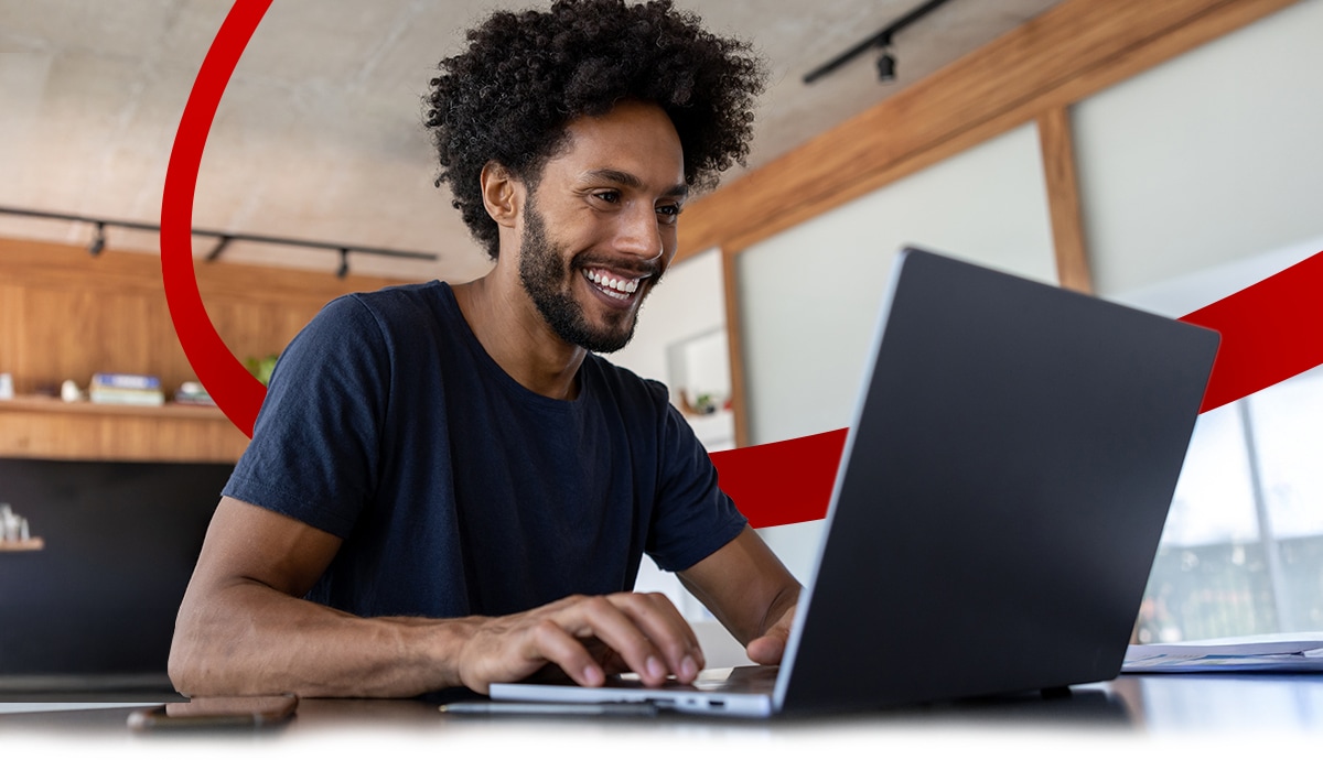 Smiling individual using an AI PC laptop computer.