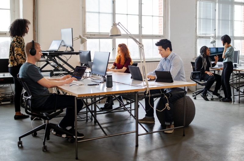 Office workers using computers in a bright, modern office.