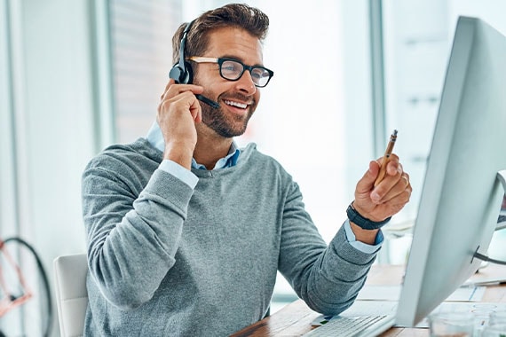 Shot of a young call centre agent working in an office account manager on the phone wearing glasses imac bike modern workplace workspace