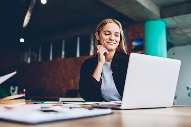 Happy business woman working on a laptop.