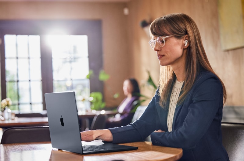 Woman working on a MacBook in a cafe.