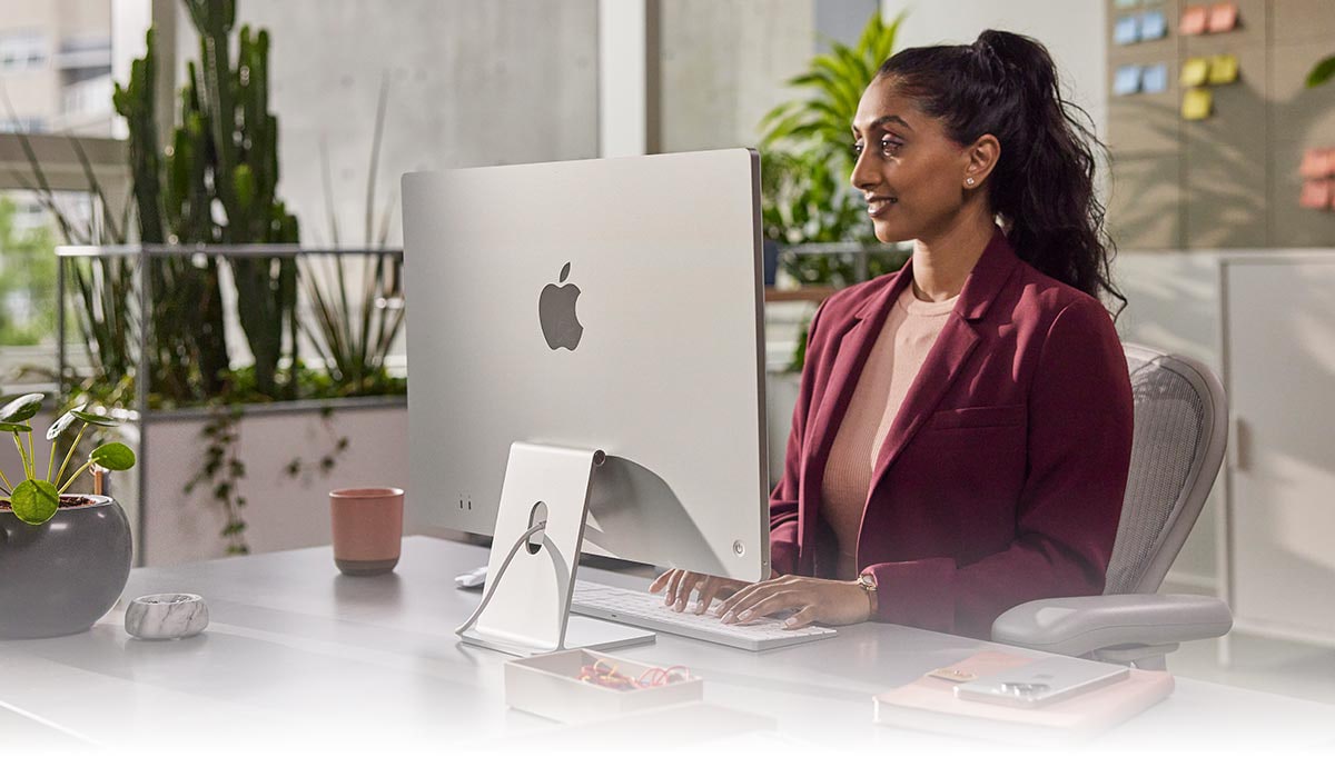 Woman working on a Apple iMac in an office.