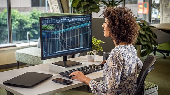 image of a woman working on AutoCAD software on a desktop computer