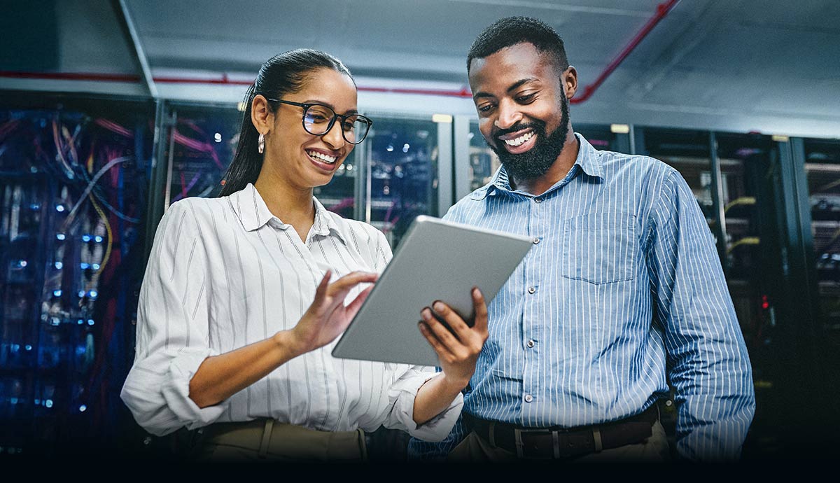 Two IT professionals review a tablet in a data center, supporting Azure Local hybrid cloud operations delivered by CDW.