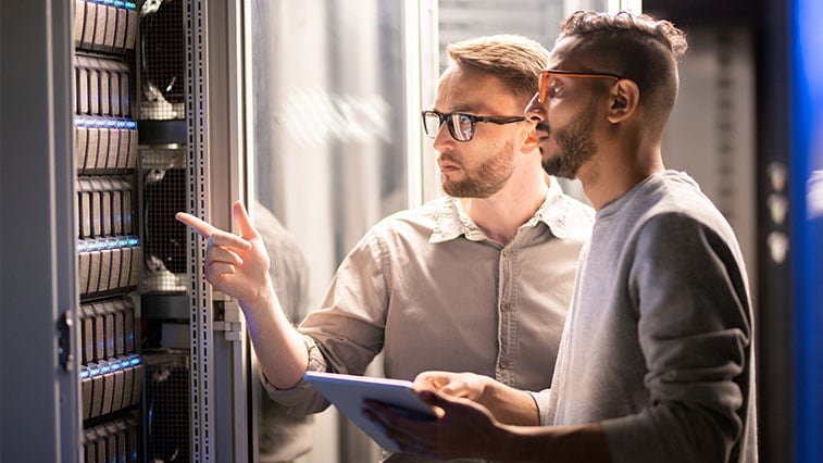 Two men in server room with tablet