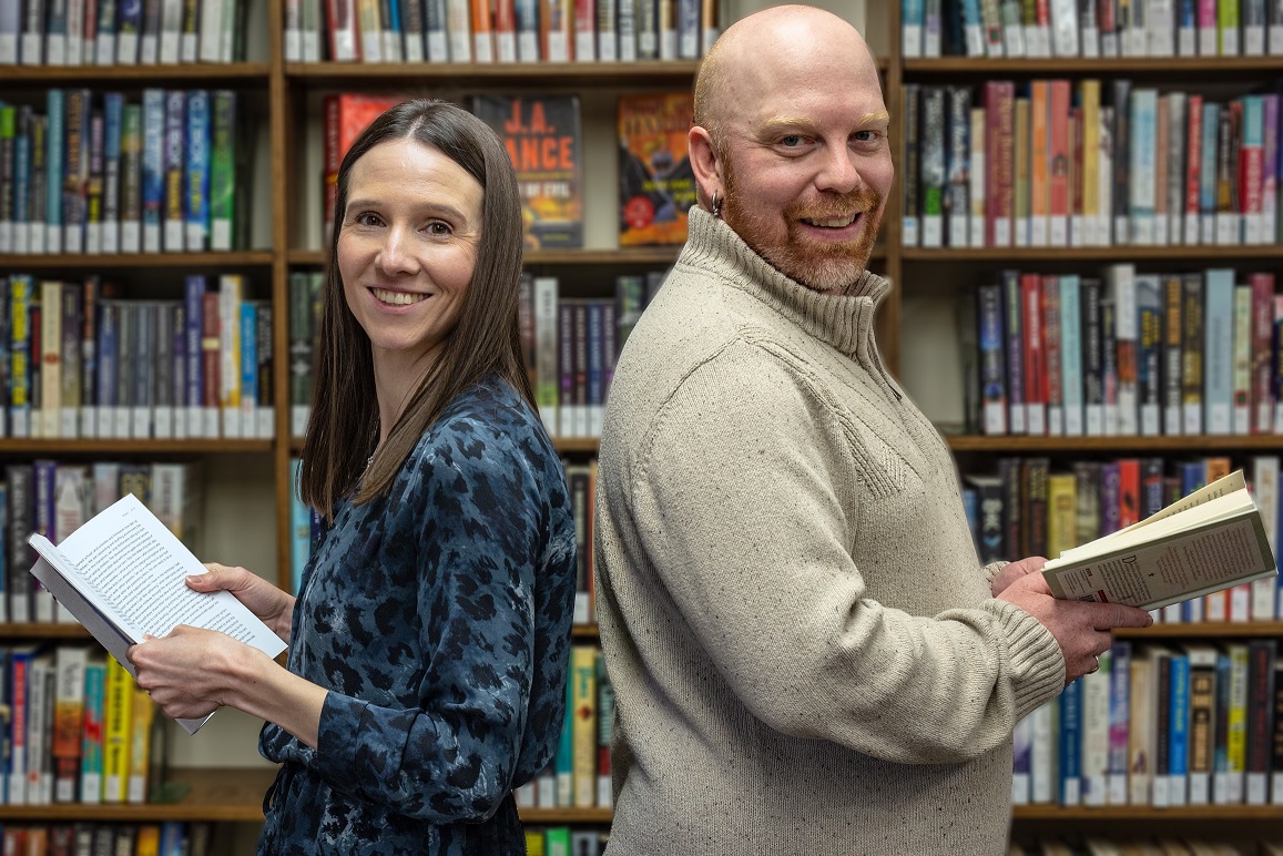 a man and woman holding books