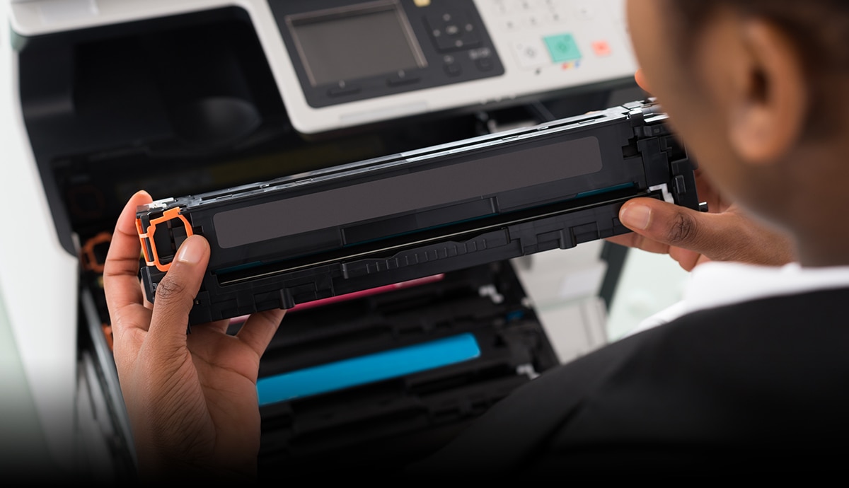 banner image of a man replacing a printer cartridge