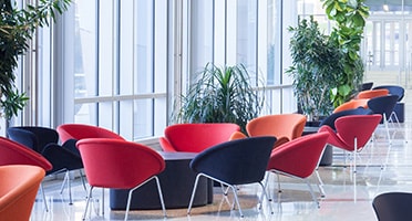 A modern office lobby with chairs and plants
