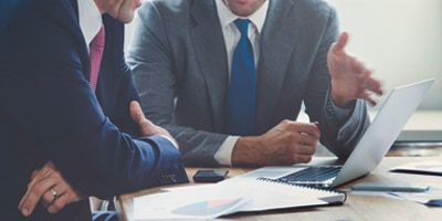 Two business people working on laptop