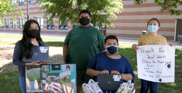 Four kids wearign masks hold sign thanking Chance the Rapper 