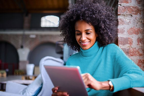 Smiling woman using digital tablet.