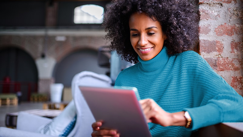 Smiling woman using digital tablet with secured Cisco firewall