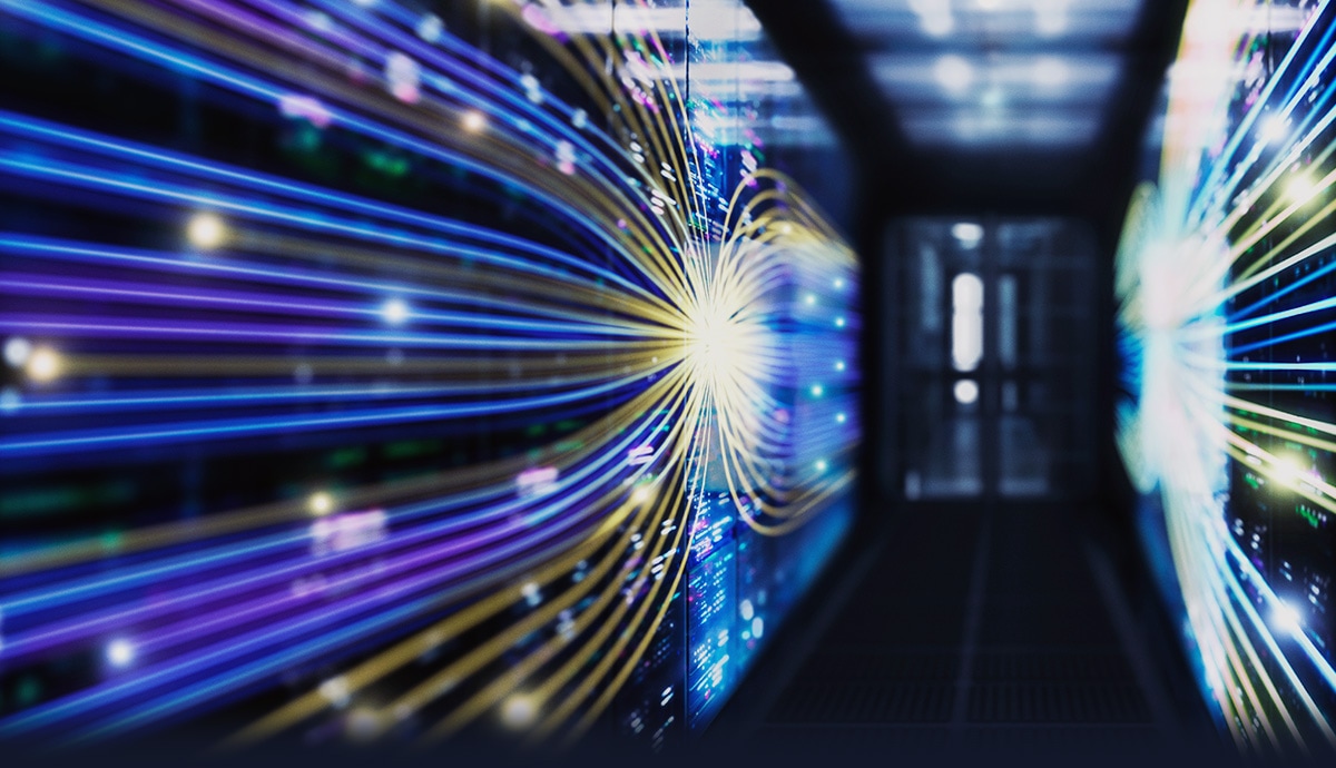 Abstract visualization of high-speed data transfer with colorful light trails in a server corridor.