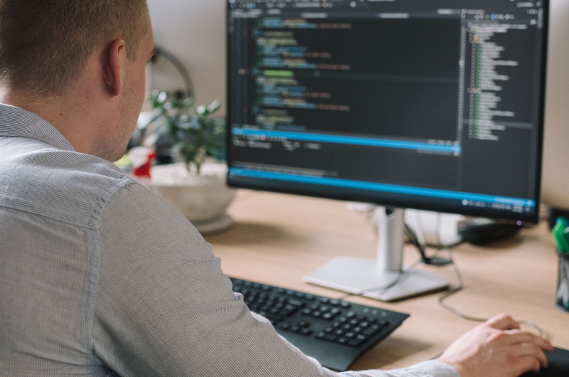 Developer working at desktop with code editor open.