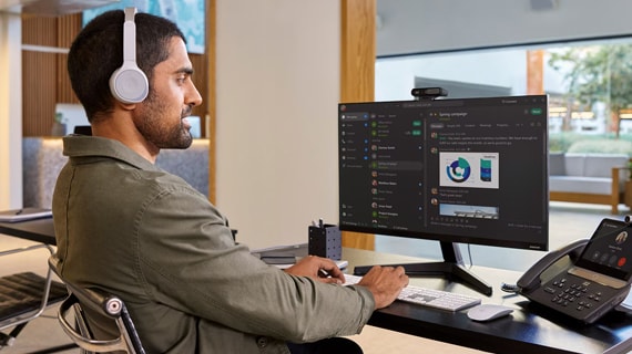 Man with headphones working on desktop computer.