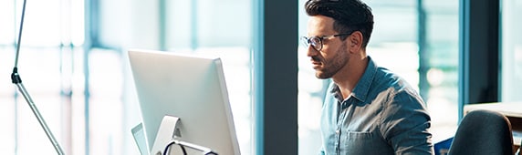 A white man sitting at a computer