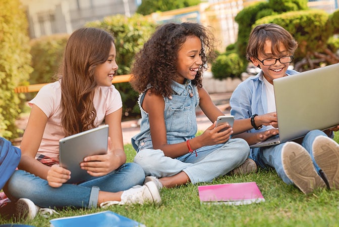 Group of kids with tablet, phone and laptop