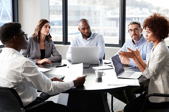 People with laptops in bright office having a meeting..