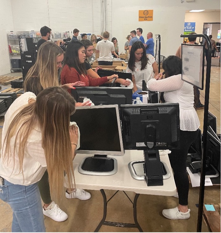 CDW interns inspect and clean desktop computers as a part of the CDW and Compudopt partnership in the Compudopt Chicago warehouse