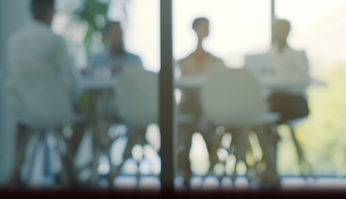 Out-of-focus office environment with employees in background.