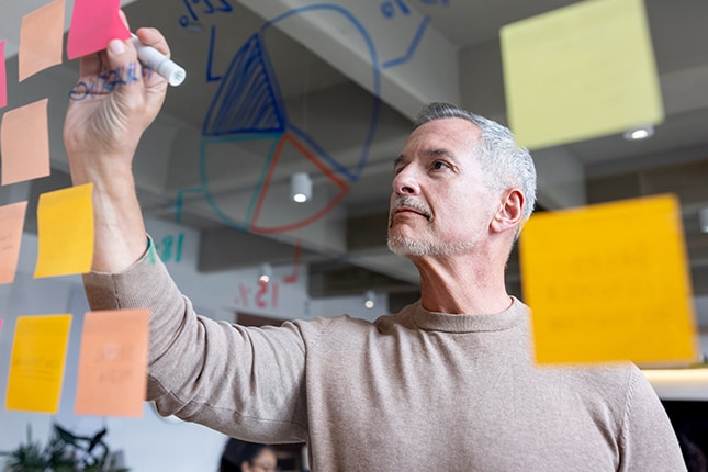 IT expert writing on a whiteboard.