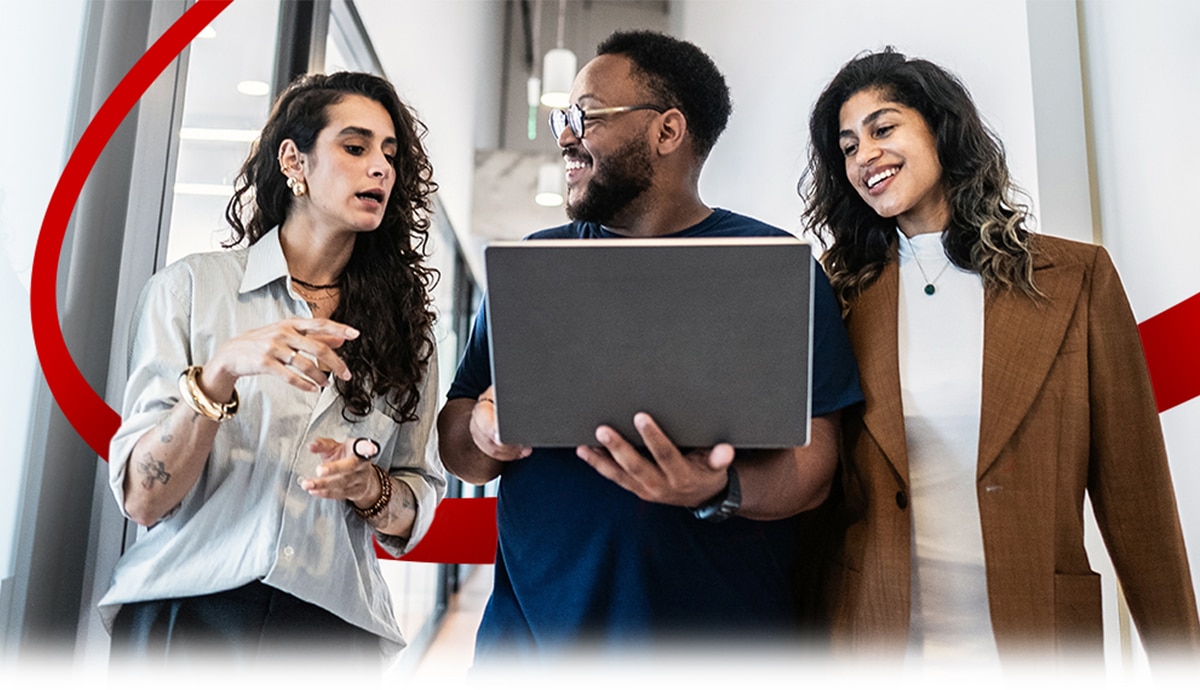Colleagues reviewing work together in a hallway setting.