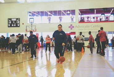 Student dribbling basketball at Advocate Center