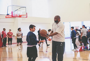 Horace Grant hands basketball to Chicago Bulls College Prep student