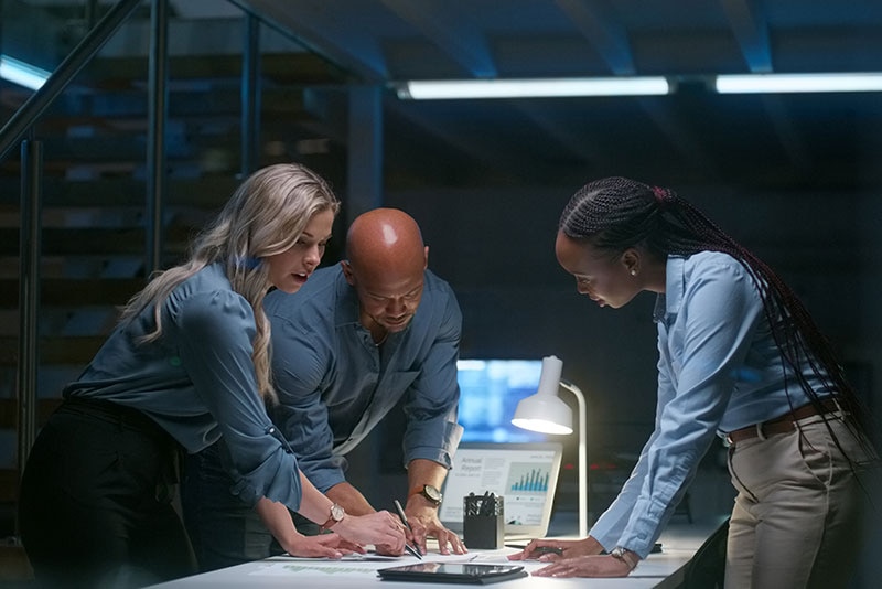 Government IT team collaborating on multicloud strategy with Dell technology solutions, analyzing data reports on a secure digital platform in a modern office