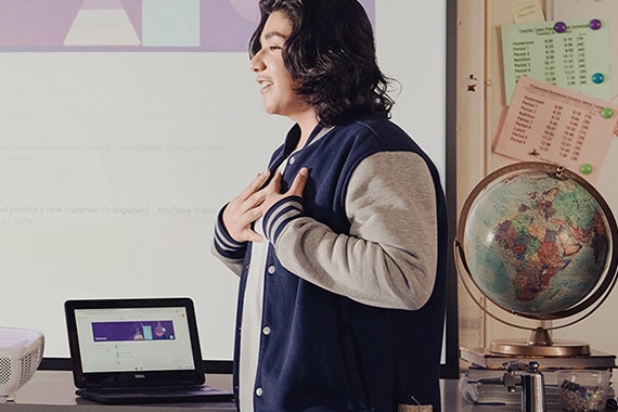 Young man presenting in front of classroom.