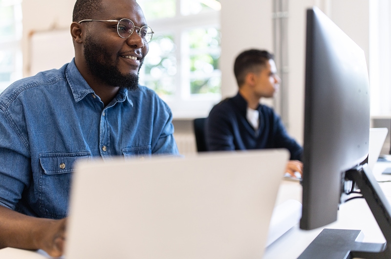 Professional working on a desktop computer in a bright, modern office.